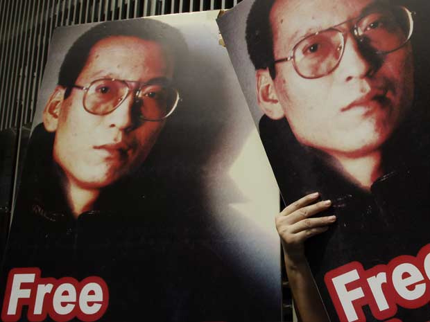 Cartazes pedem a libertação do dissidente chinês Liu Xiaobo durante protesto por democracia na China (Foto: AP)