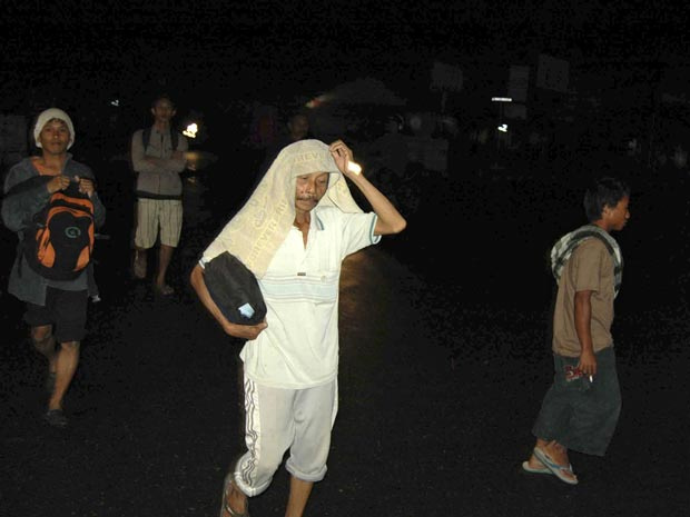 Moradores da cidade de Padang correm na noite desta segunda-feira (25), assustados com o terremoto. (Foto: AFP)