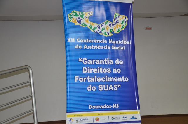 Banner do XII Conferência Municipal de Assistência Social., exposto na entrada do salão de eventos da Aced. 