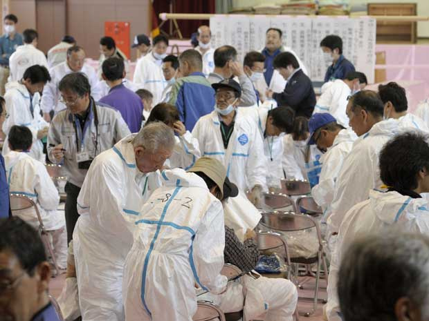 92 moradores vestem roupas de proteção para uma breve visita às suas casas localizadas dentro da zona proibida da região da usina nuclear de Fukushima Dai-ichi. (Foto: Kyodo News / AP Photo)