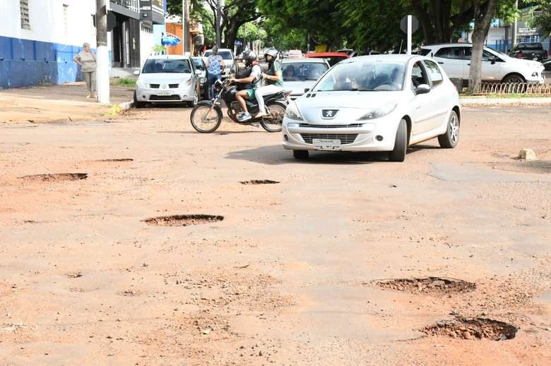 Partes da rua Mato Grosso estão com malha asfáltica comprometida - Crédito: Hedio Fazan/Dourados News