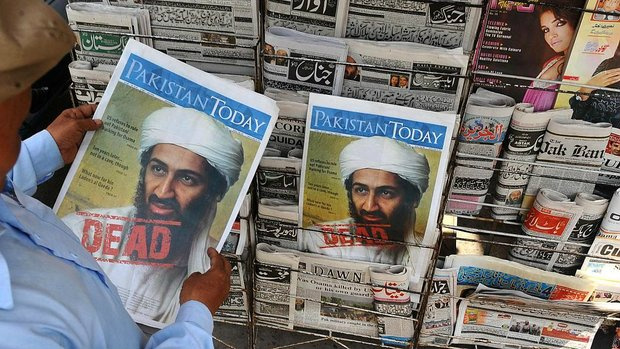 Paquistanês lê jornal com informações sobre a morte de Osama bin Laden (Arif Ali/AFP)
