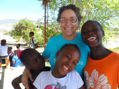 Missionária religiosa com crianças haitianas atendidas pelo projeto