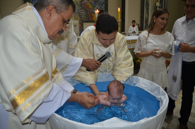 Pe. Crispim batizando o bebê. durante missa de véspera de Natal, na catedral Imaculada Conceição de Dourados. 