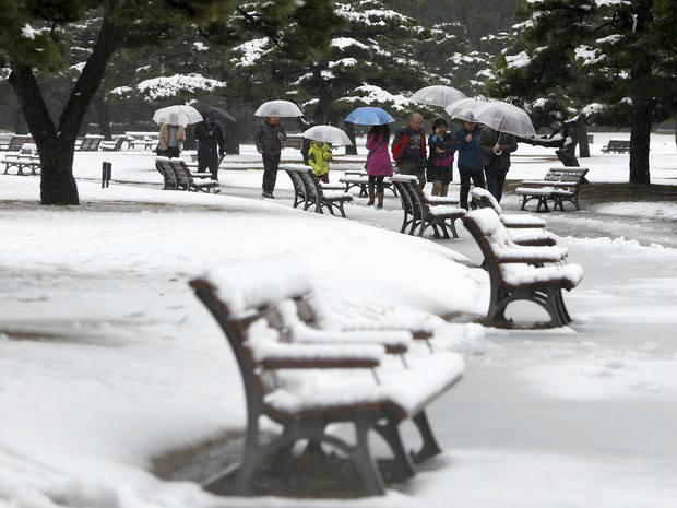 Pessoas carregam guarda-chuvas em rua coberta de neve próxima ao Palácio Imperial em Tóquio, no Japão (Foto: REUTERS/Yuya Shino)