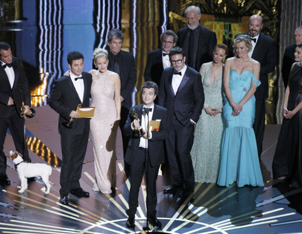Com elenco e equipe de 'O artista' ao fundo, produtor Thomas Langmann discursa no Oscar após longa vencer o prêmio de melhor filme (Foto: Gary Hershorn/Reuters)
