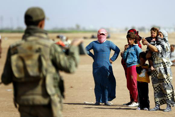 Refugiados sírios aguardam na fronteira com a Turquia para fugir dos ataques do Estado Islâmico (EPA/Sedat Suna/Agência Lusa)EPA/Sedat Suna
