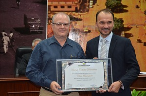 Clóvis Batagliotti, recebe das mãos do vereador Junior Rodrigues o título de 'Cidadão Douradense'.