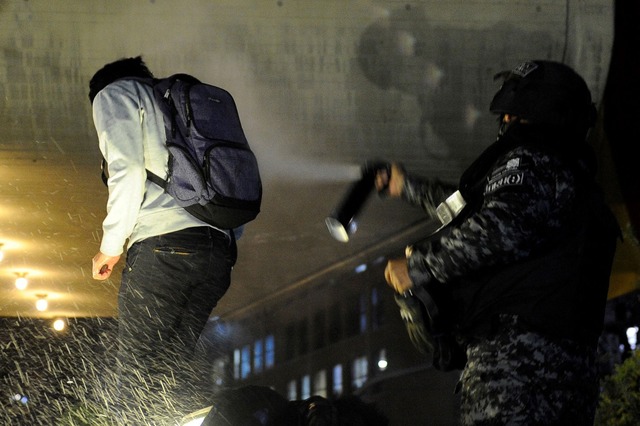 Policial joga spray de pimenta em apoiador do principal candidato presidencial da oposição a Evo Morales, Carlos Mesa, durante protesto em La Paz, na Bolívia — Foto: Jorge Bernal / AFP